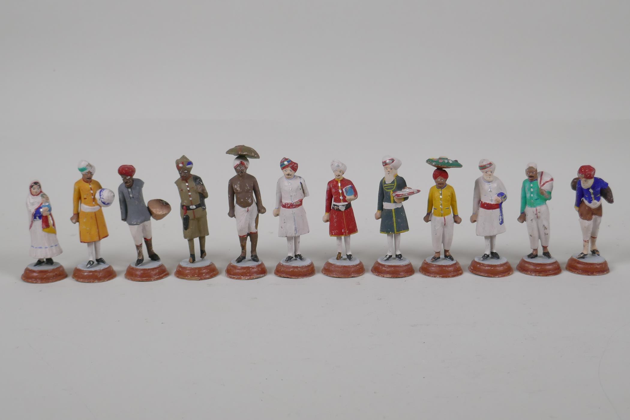 Twelve Indian painted terracotta figures, depicting various professions, AF, largest 3½"