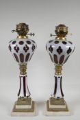 A pair of Bohemian style ruby glass oil lamps, with brass & marble mounts. 20" high