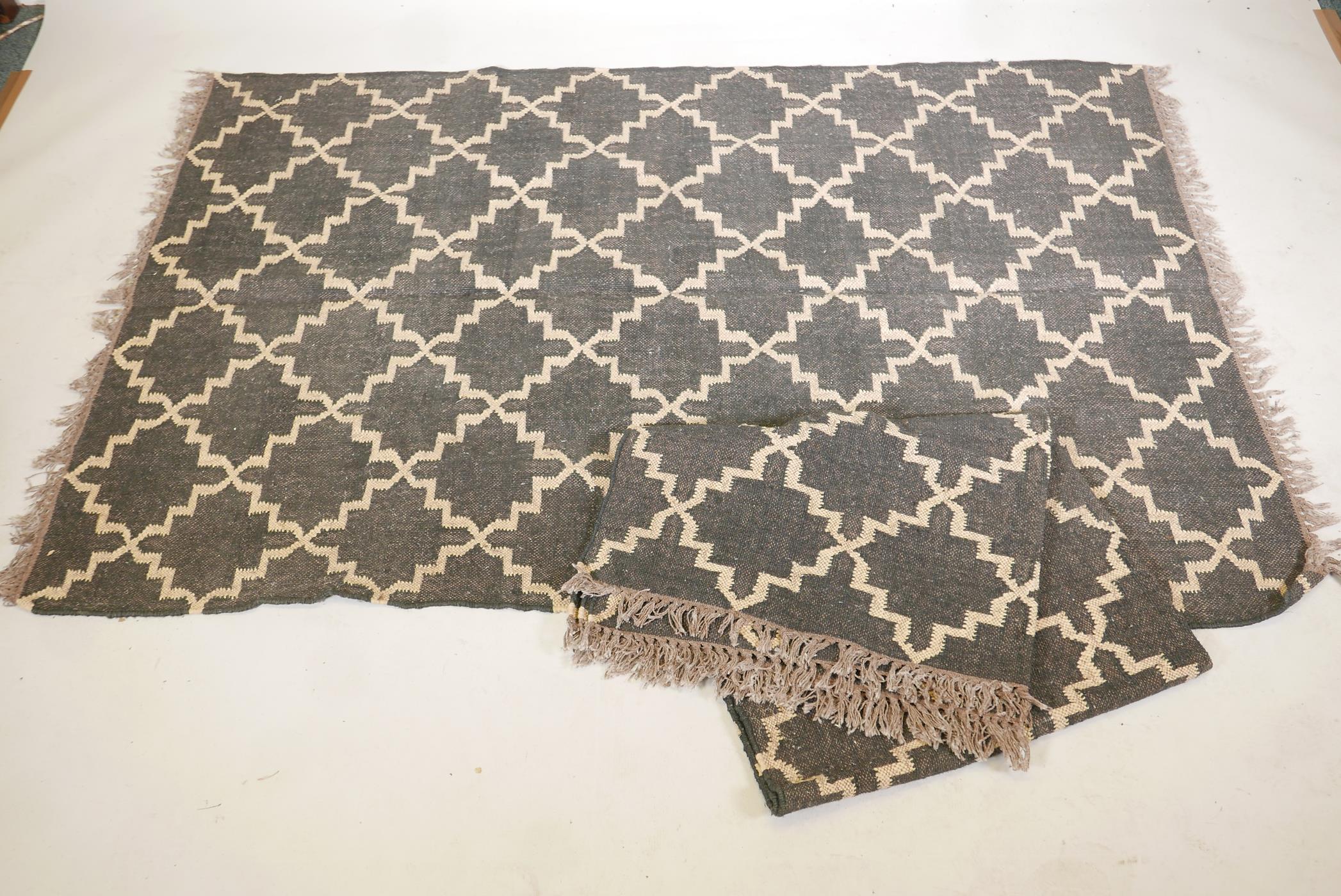 A pair of black ground, woven wool rugs, with a natural coloured repeating geometric pattern. 73" - Image 4 of 4