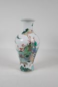 A Chinese Kangxi style famille verte porcelain vase decorated with travellers in a landscape, leaf