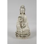 A blanc de chine porcelain Quan Yin seated on a lotus flower throne, impressed marks verso, 10" high