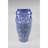 A Persian blue ground pottery two handled vase, with iznik style scrolling decoration, signed to