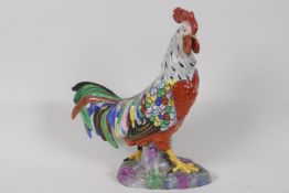 A brightly coloured porcelain figurine of a cockerel, 9" high