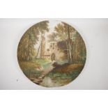 A large porcelain charger decorated with a figure in a wooded churchyard, 15" diameter