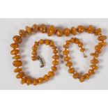 A string of 57 graduated natural amber beads, 20" long, 33g