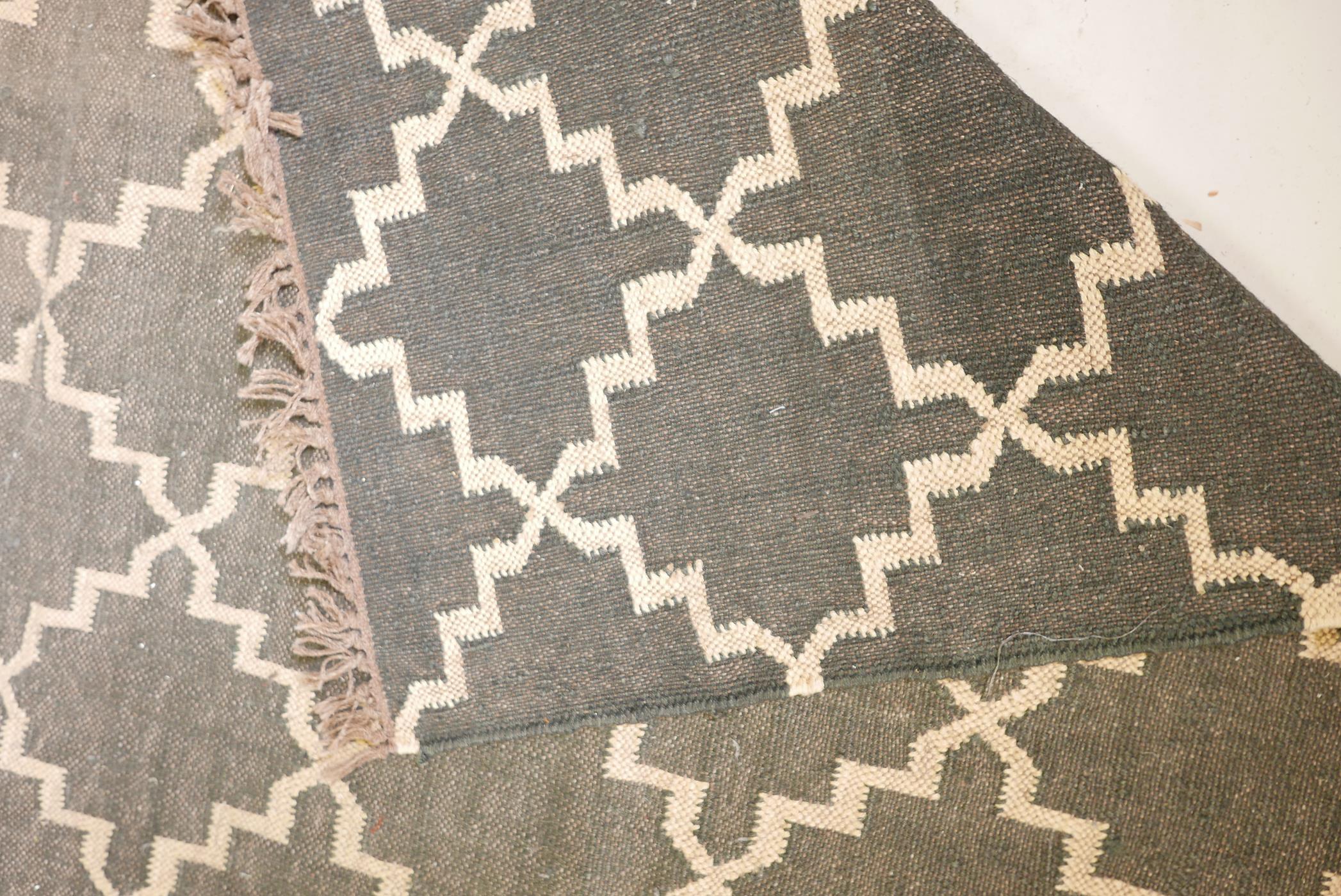 A black ground woven wool carpet, with a natural coloured repeating geometric pattern. 74" x 110" - Image 4 of 4