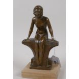 An Art Deco bronzed spelter figurine of a nude girl seated on a bench, 7½" high