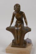 An Art Deco bronzed spelter figurine of a nude girl seated on a bench, 7½" high