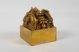 A Chinese gilt bronze seal, the knop in the form of a dragon, 3½" x 3½"