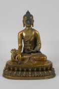 A Sino Tibetan gilt metal buddha, seated on a lotus throne. Impressed double vajra mark to the base,