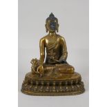 A Sino Tibetan gilt metal buddha, seated on a lotus throne. Impressed double vajra mark to the base,