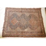 An antique Persian hand woven wool carpet with central medallions and stylised bird designs, the