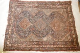 An antique Persian hand woven wool carpet with central medallions and stylised bird designs, the