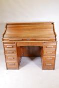 A 1930s oak roll top pedestal desk with nine drawers and slides to each pedestal, serpentine tambour