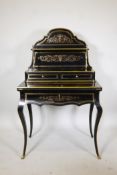 A 19th C French ebonised, brass mounted and inlaid writing desk, the upper section with a shaped
