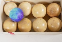 A box containing x8 C19th carved ivory billiard balls, plus another dyed blue. 2" diameter