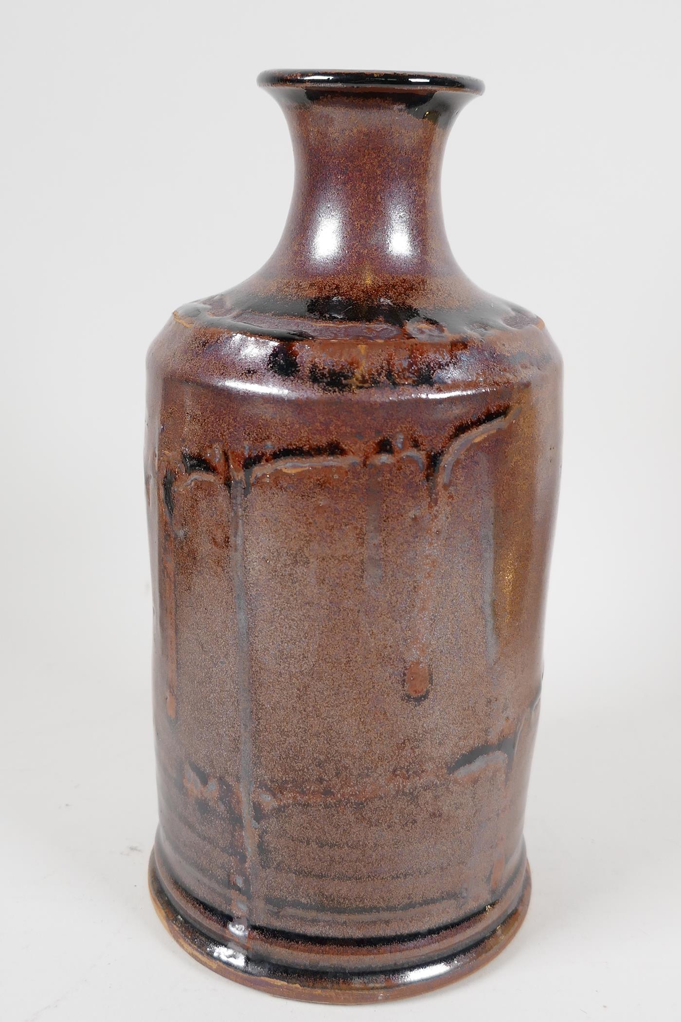 A drip glazed stoneware bottle vase of tubular design with narrow neck, 7½" long