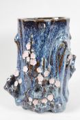 An Oriental stoneware vase, formed as a tree trunk with embossed prunus blossom, on a flambe