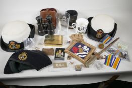 A collection of military and naval ephemera to include WWI binoculars, Wren's hats, bayonet, replica