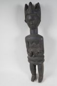 An African carved wood fertility figure holding a baby, 23" high