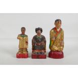 A Chinese carved and painted wood figure of an emperor seated on a throne, and two others, largest