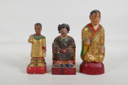 A Chinese carved and painted wood figure of an emperor seated on a throne, and two others, largest