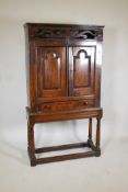Antique bread and cheese cupboard, with carved and pierced hinged cover to the top shelf over two