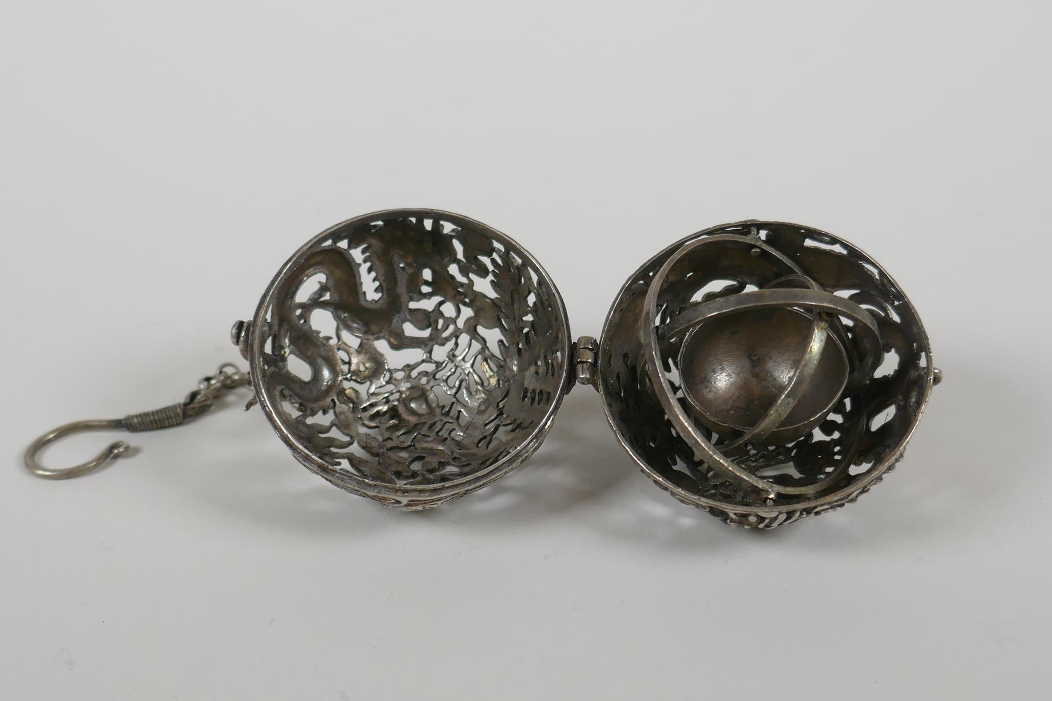 A Chinese white metal pierced ball incense burner, with a gimbal mouted reservoir, 2" diameter - Image 2 of 3