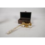 A pair of brass and mother of pearl opera glasses, in a hardwood box, 5¼" long