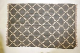 A pair of black ground, woven wool rugs, with a natural coloured repeating geometric pattern. 73"