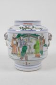 A famille verte porcelain jar with two fo dog mask handles, decorated with figures in a garden,