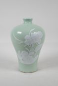 A celadon ground porcelain meiping vase with raised white enamelled floral decoration, Chinese