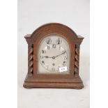 An oak cased mantle clock, with silvered dial and Arabic numerals, the German movement striking on