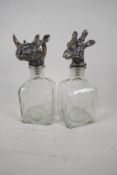 A pair of square section decanters with plated stoppers in the form of animal heads. 10" high