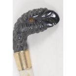 A C19th horn parasol handle, carved as a parrots head. 2" long