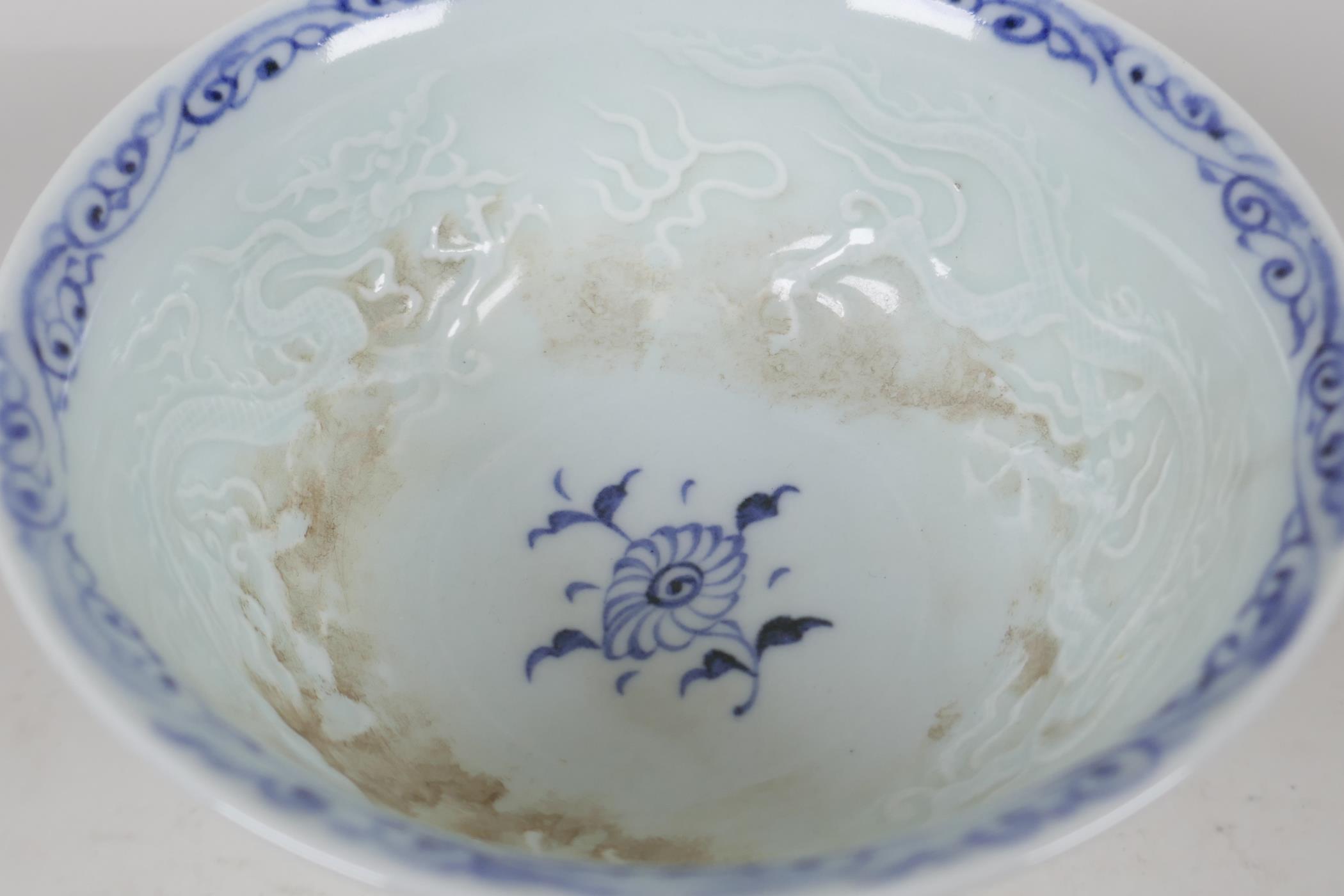 A Chinese blue & white porcelain stem cup, painted and embossed with dragons and clouds. 5" diameter - Image 4 of 5