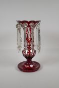 A Bohemian ruby glass lustre with flash cut decoration, 1 lustre missing, 12½" high
