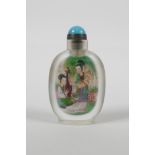 A Chinese reverse decorated glass snuff bottle depicting two women in a garden to each side, 3½"