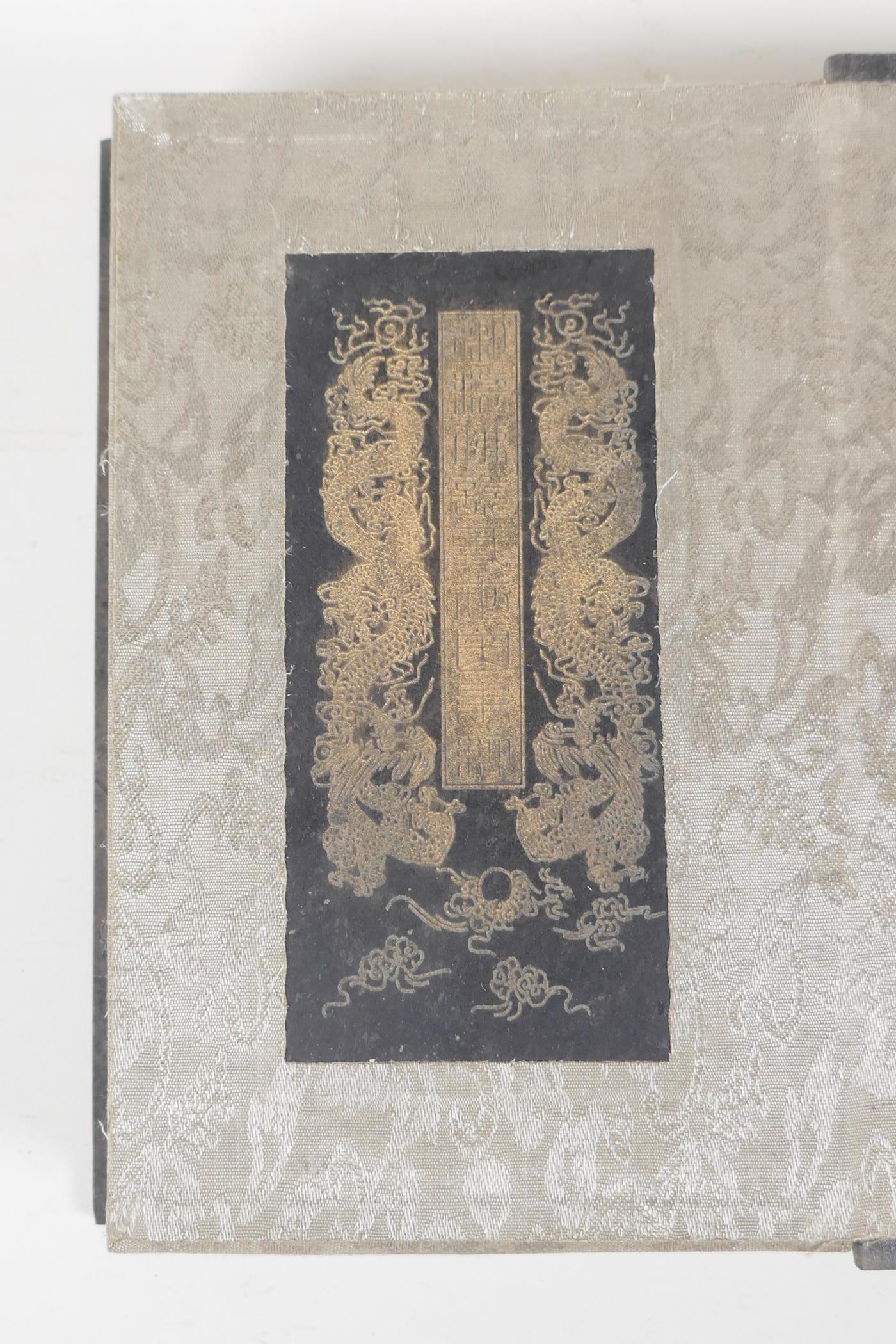 A Chinese silk and wood bound book containing black hardstone tablets with engraved and gilt - Image 3 of 9