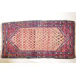 An antique, deep pile, hand woven wool Persian rug. With geometric designs in a central panel & blue