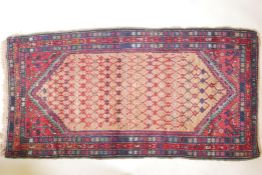 An antique, deep pile, hand woven wool Persian rug. With geometric designs in a central panel & blue