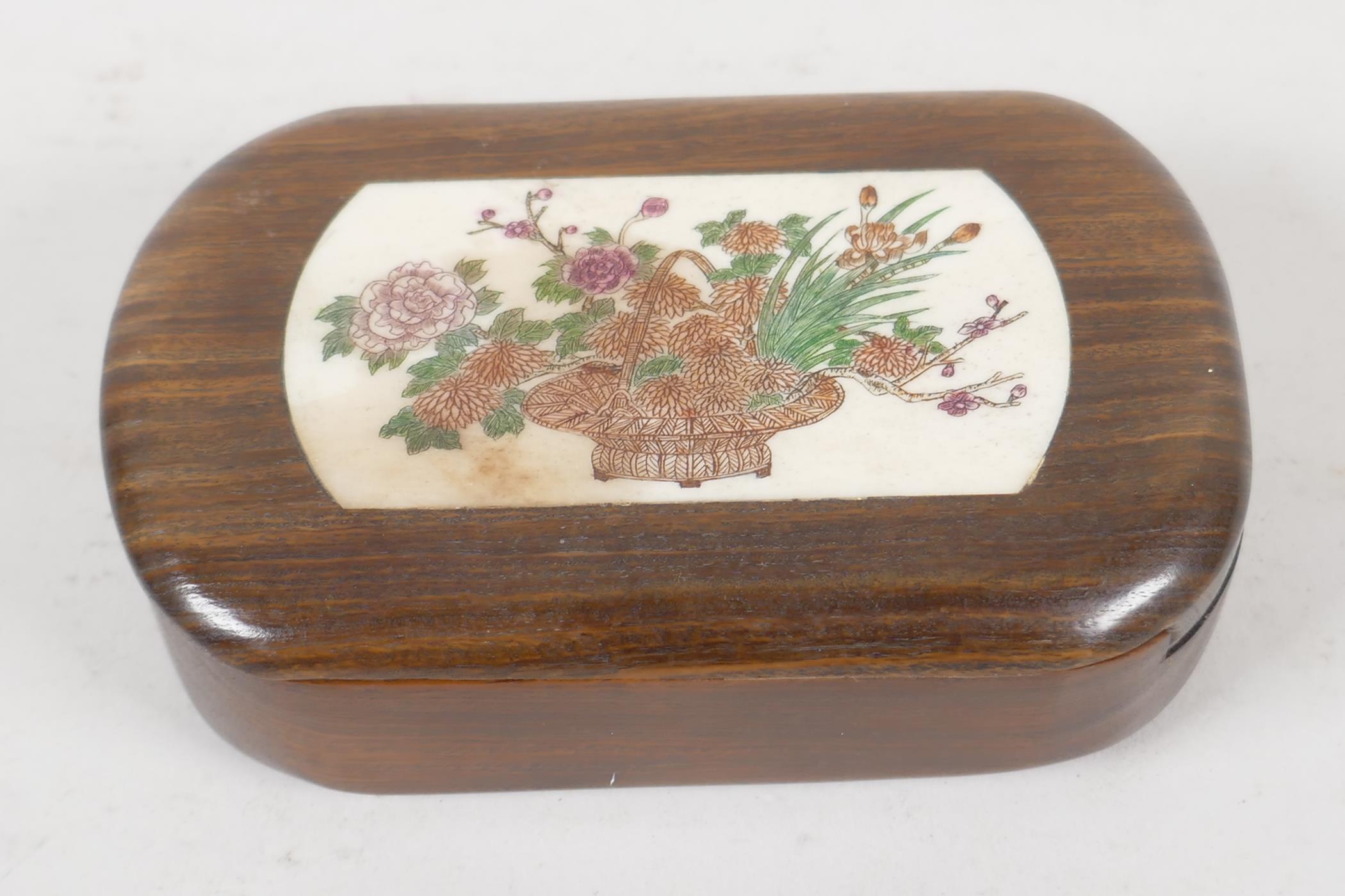 A Japanese hardwood trinket box. With a sliding lid, inset with bone panel, engraved and painted