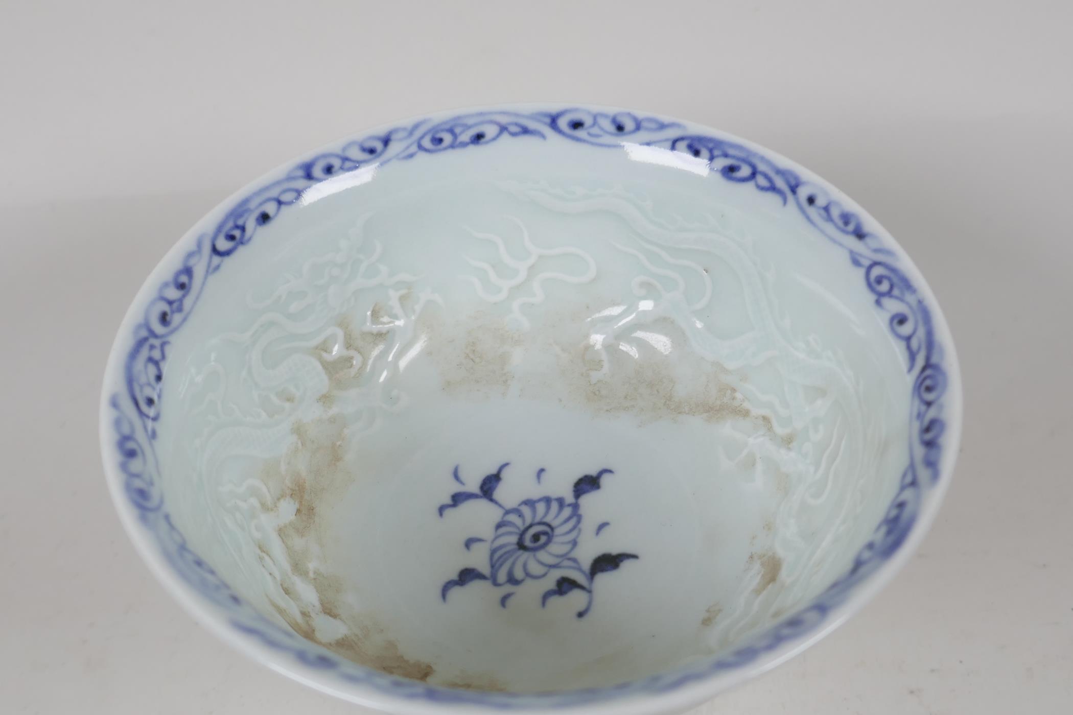 A Chinese blue & white porcelain stem cup, painted and embossed with dragons and clouds. 5" diameter - Image 5 of 5