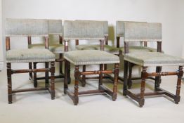 A set of six French dining chairs with upholstered solid backs and seats, raised on turned
