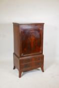 An early C20th figured mahogany music/folio cabinet. Fitted with shelves over two drawers and