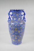 A Persian blue ground pottery two handled vase, with iznik style scrolling decoration, signed to