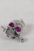 A sterling silver skull pendant, with red stone eyes 1" long