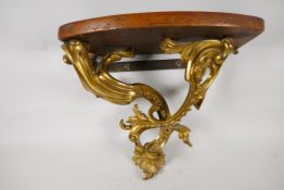 An ornate ormolu wall bracket, cast as scrolling leaves & having a walnut top. 12" deep x 13" wide