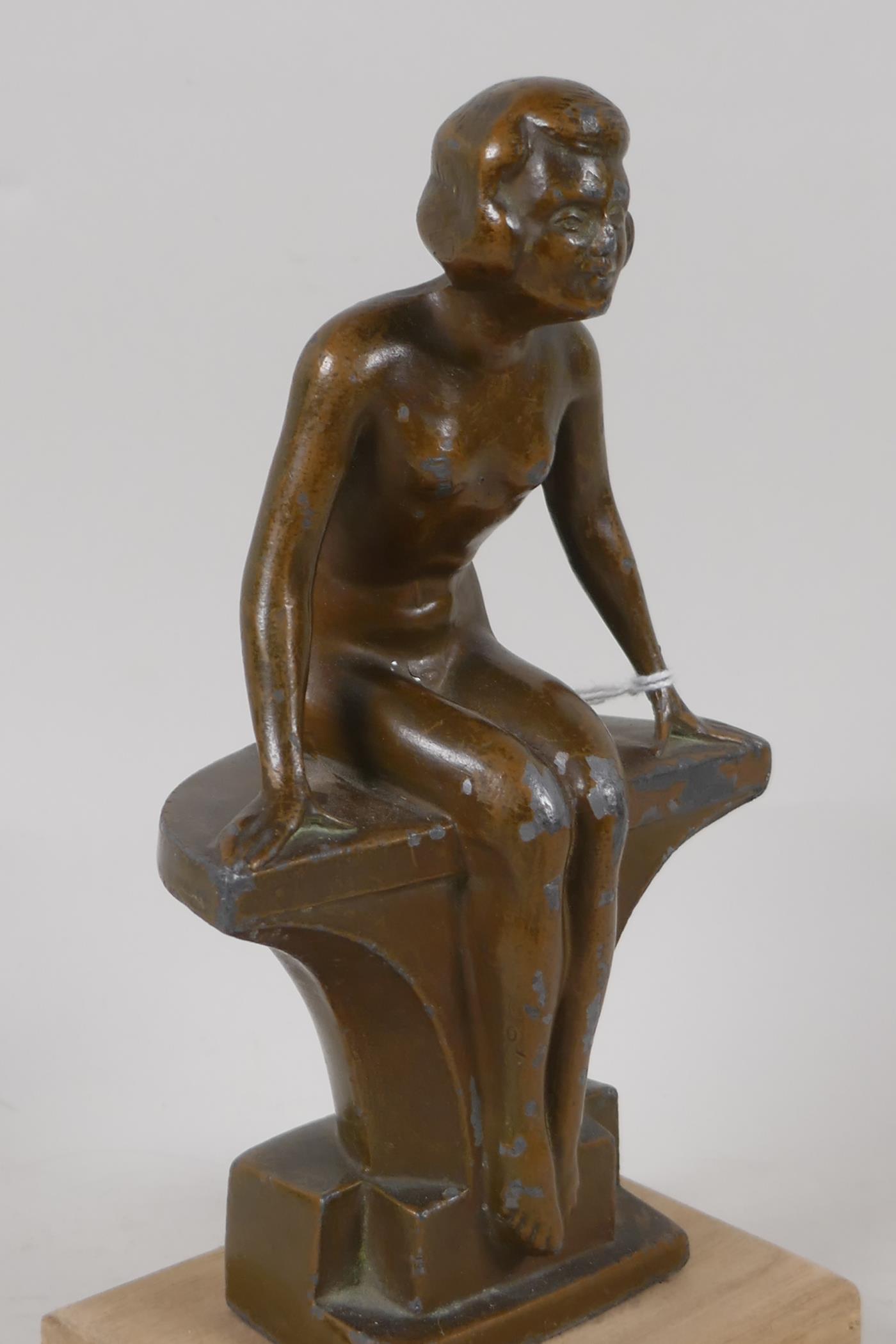 An Art Deco bronzed spelter figurine of a nude girl seated on a bench, 7½" high - Image 3 of 3