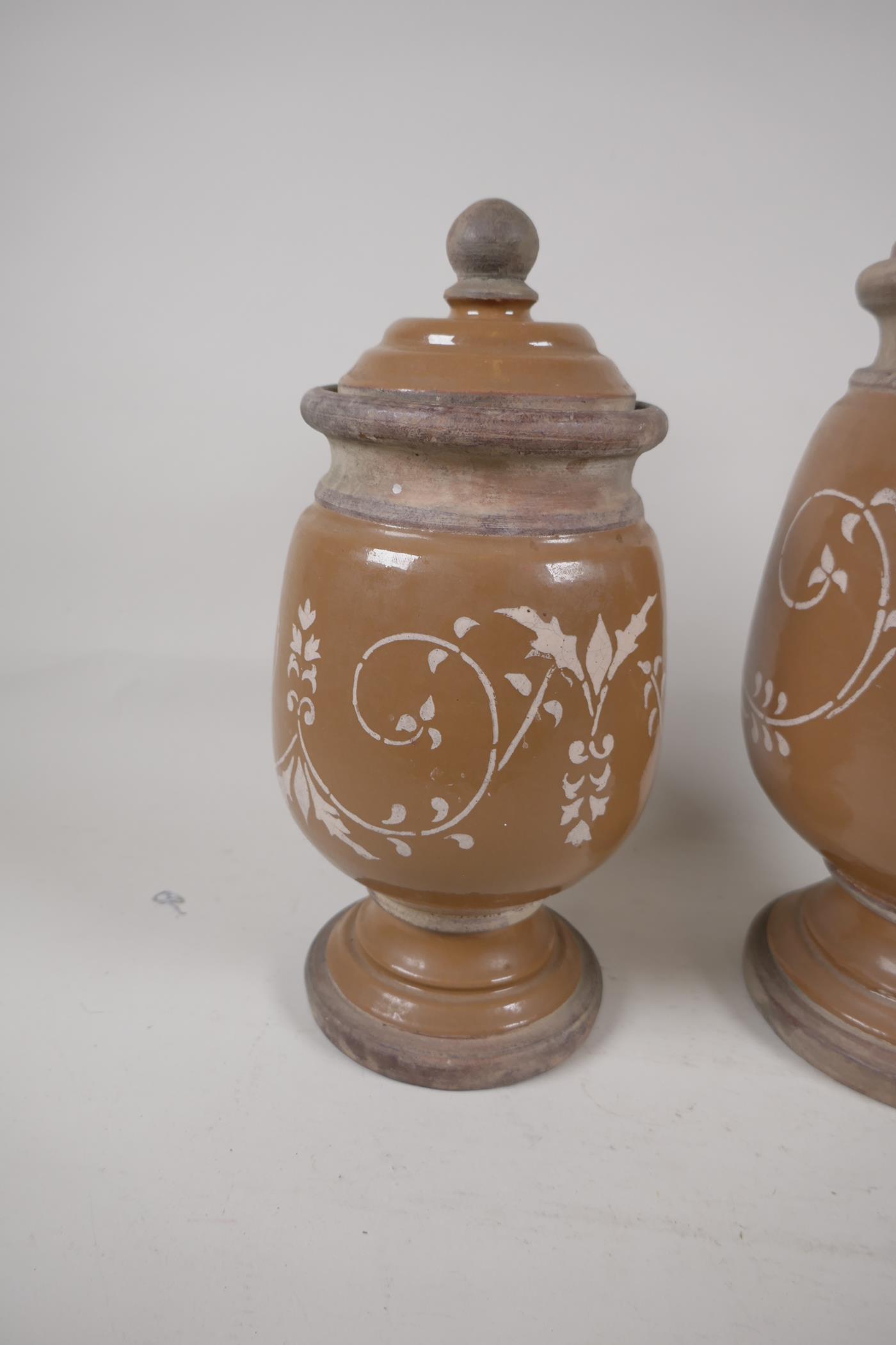 Two French stoneware lidded storage jars on pedestal bases with painted scroll decoration, largest - Image 3 of 3